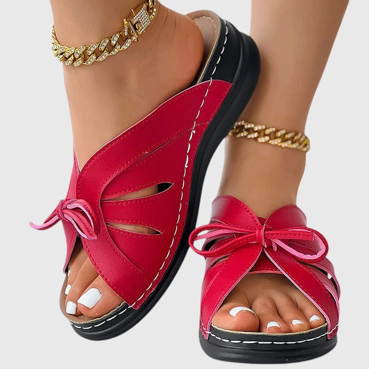 A woman in blue slip-on band sandals stepping out easily, feet cushioned and comfortable.