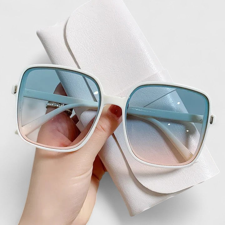 A woman wearing vintage-inspired oversized sunglasses in the sun, elegant and relaxed.