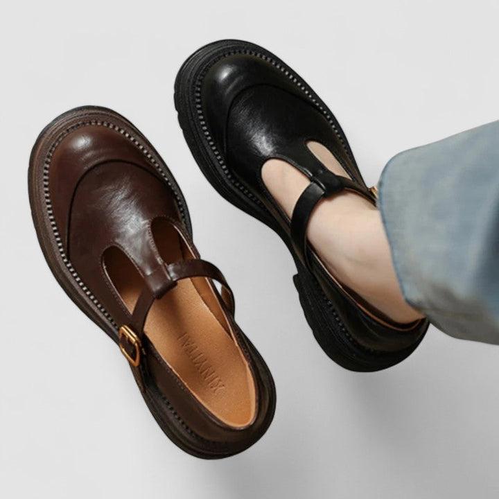 Woman wearing brown Mary Stacey comfort shoes with a T-strap, standing on a city footpath.
