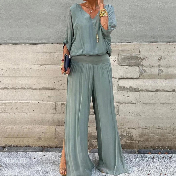 A woman wearing a flowing lounge two-piece set with a V-neck top and wide-leg pants.