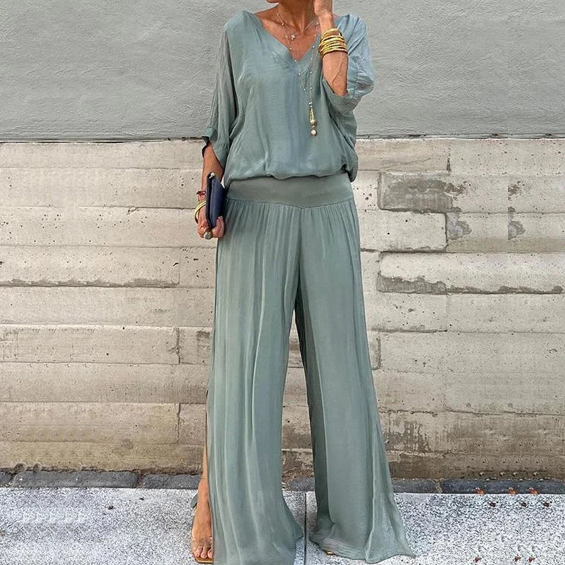 A woman wearing a flowing lounge two-piece set with a V-neck top and wide-leg pants.
