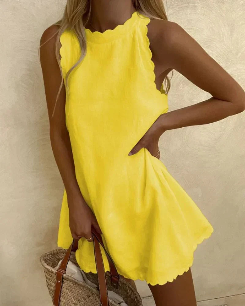 Woman wearing the Diane ruffle-neck dress in yellow, twirling on a sunny street.