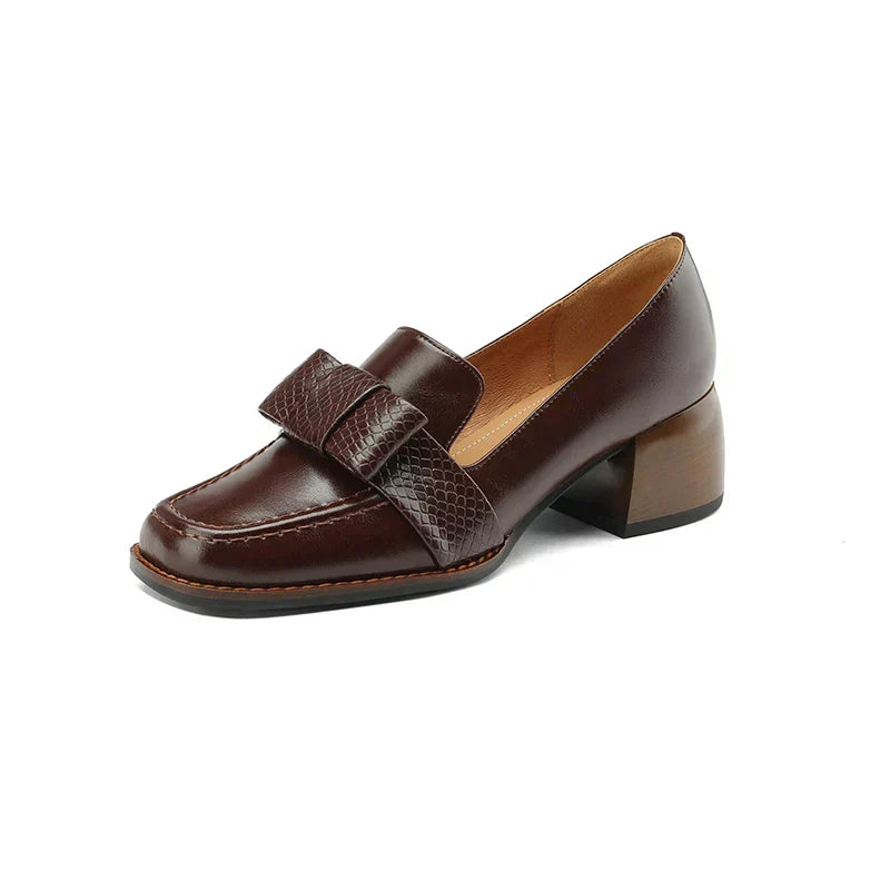 A woman wearing classic loafers with a subtle knot detail and tailored pants