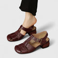 Black closed-toe sandals with a slim T-strap, buckled slingback and a low block heel.