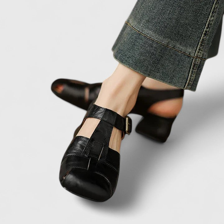 Black closed-toe sandals with a slim T-strap, buckled slingback and a low block heel.