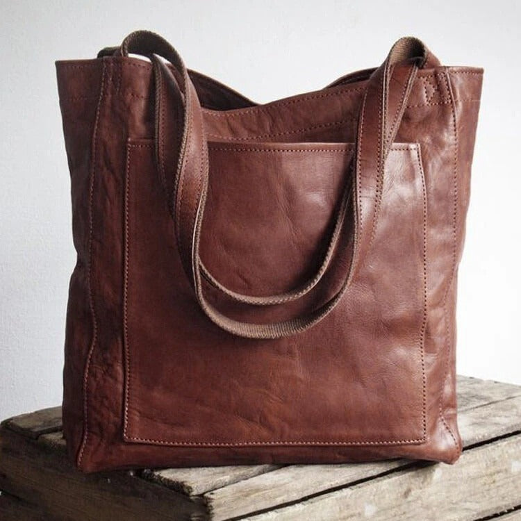 A woman holding a classic handbag with a rich finish by her side