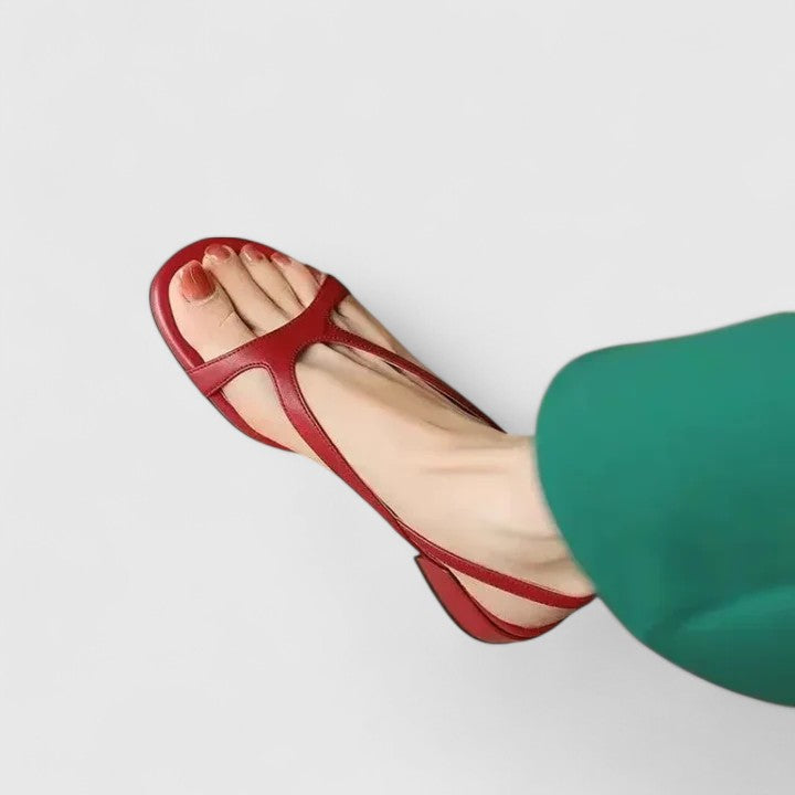Cream toe-post sandals with a slingback buckle and a block heel set with a pearl.
