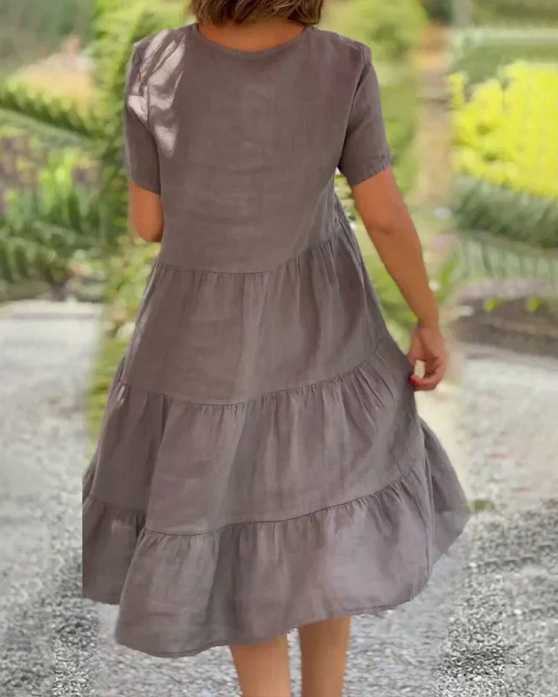 Woman wearing the Bonnie™ V-neck summer dress with a soft layered skirt, strolling on a sunny afternoon.