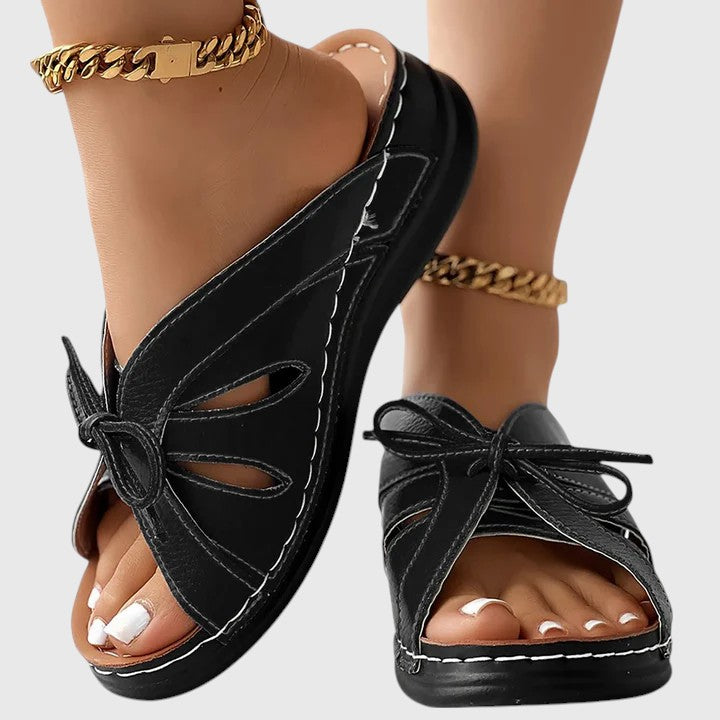 A woman in blue slip-on band sandals stepping out easily, feet cushioned and comfortable.