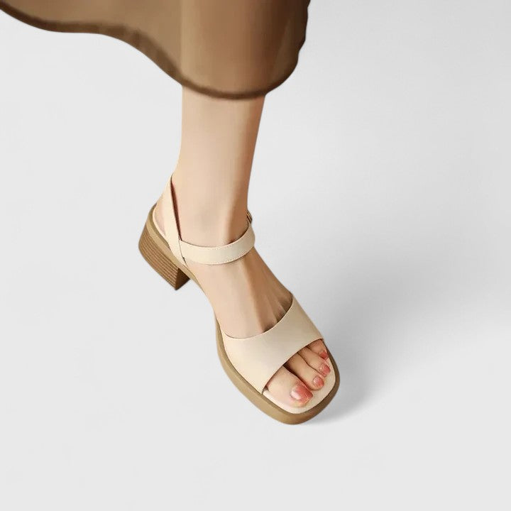 A woman in brown block heel sandals with an ankle strap, dressed for the day.
