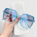 A woman running errands in town wearing classic square sunglasses, calm and stylish.