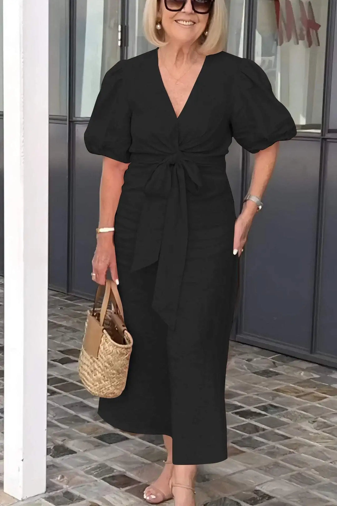 Woman wearing the Christina bow-front midi dress with puff sleeves at a garden party.
