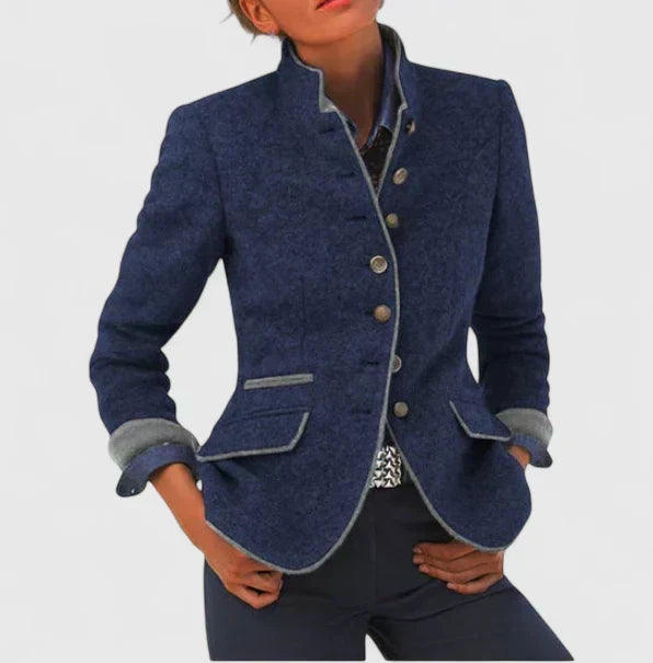 A woman wearing a structured tailored jacket with a defined waist over jeans, looking confident.