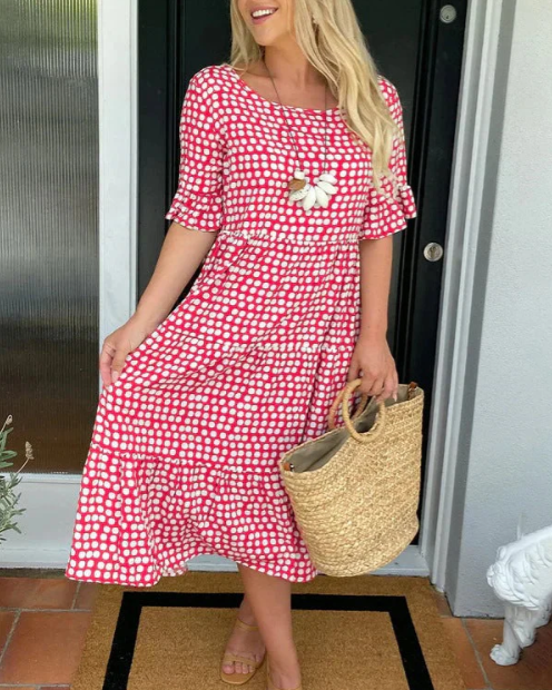 A woman wearing the Tammy short sleeve midi dress with a flowing skirt on a warm day.