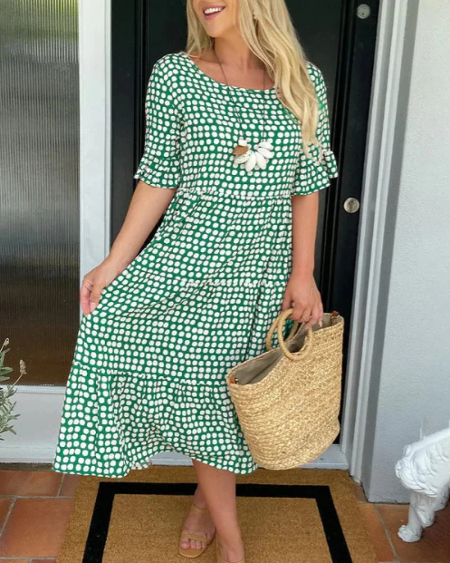 A woman wearing the Tammy short sleeve midi dress with a flowing skirt on a warm day.