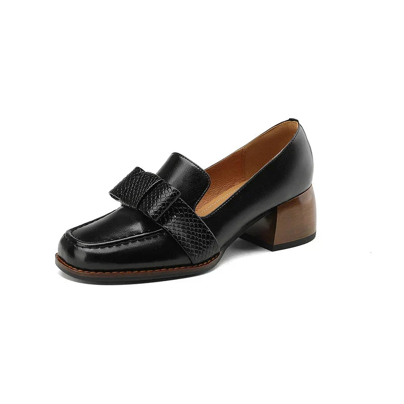 A woman wearing classic loafers with a subtle knot detail and tailored pants