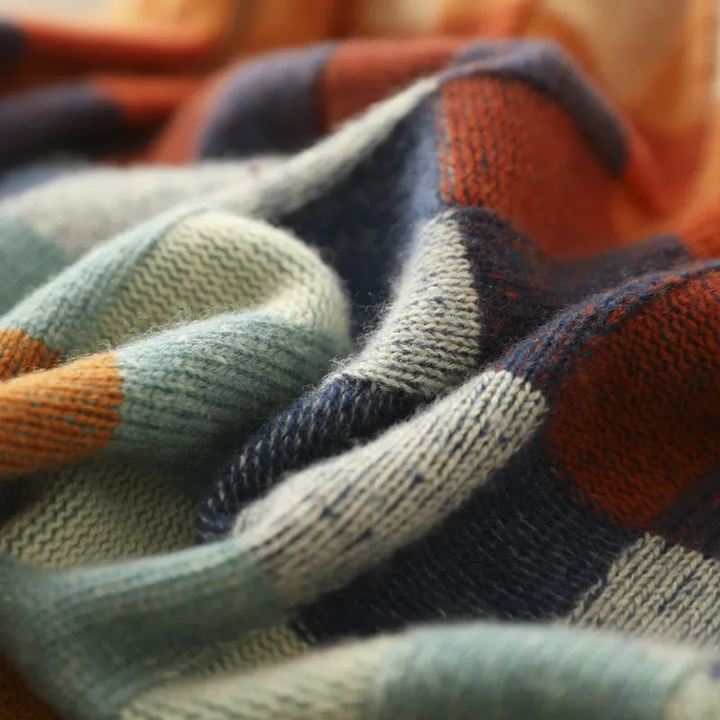 A woman wearing a colourful retro check sweater, relaxed and cosy on a cool fall morning.
