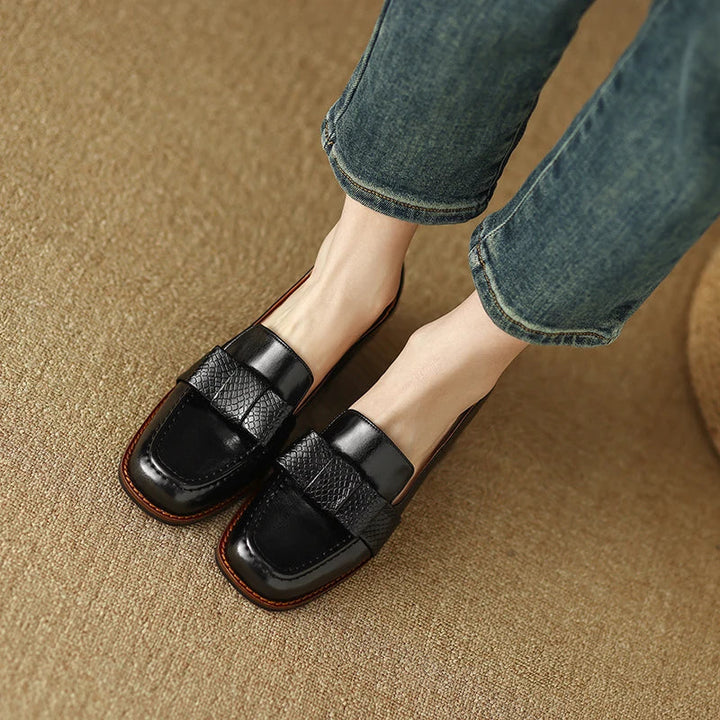 A woman wearing classic loafers with a subtle knot detail and tailored pants