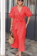 Woman wearing the Christina bow-front midi dress with puff sleeves at a garden party.