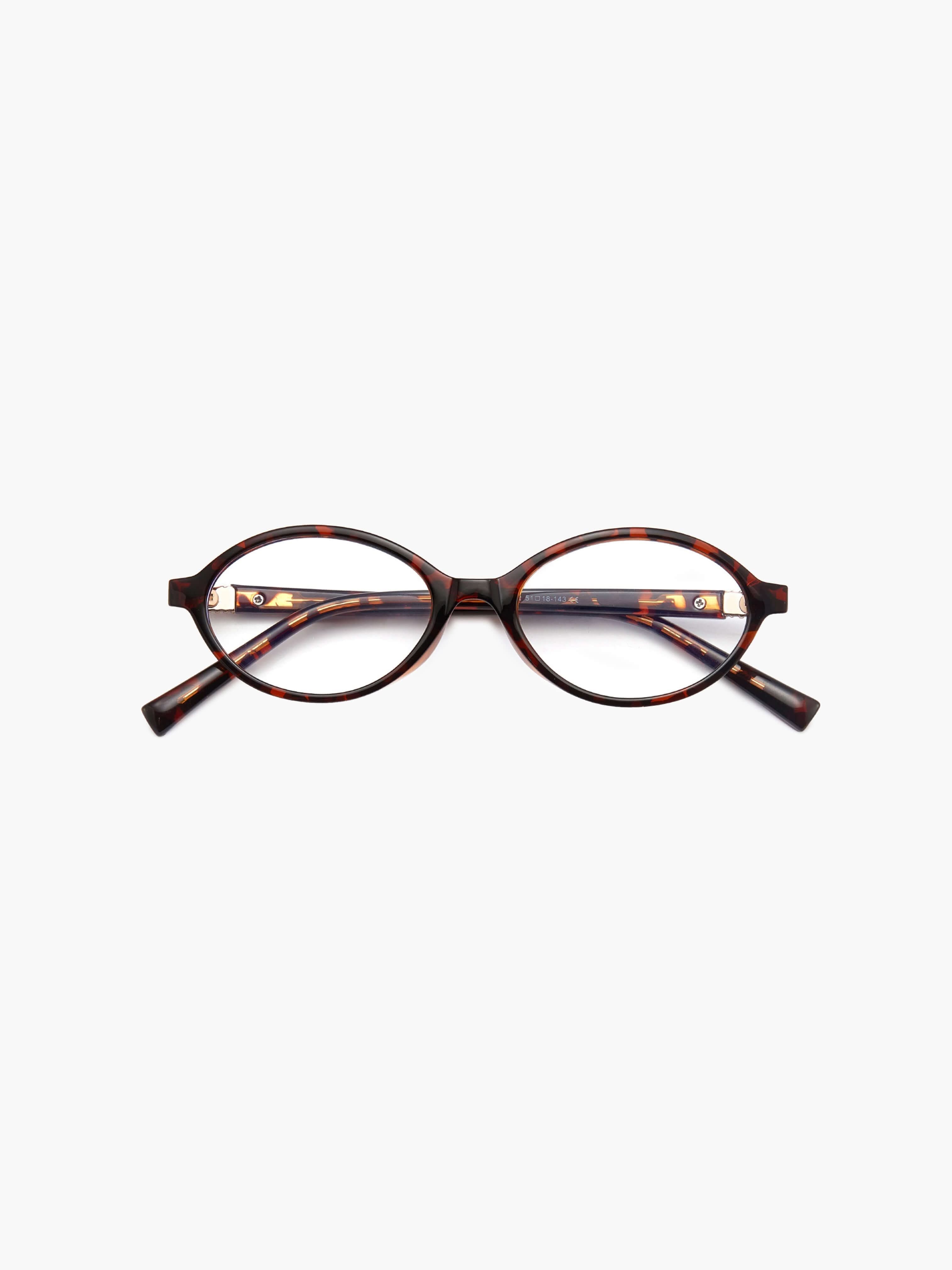 A woman wearing minimalist blue-light reading glasses while relaxing at home.
