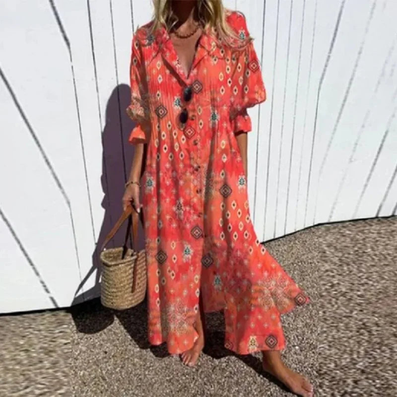 Woman wearing the Gail™ leaf print maxi dress with a button front, walking along the coast in a light breeze.