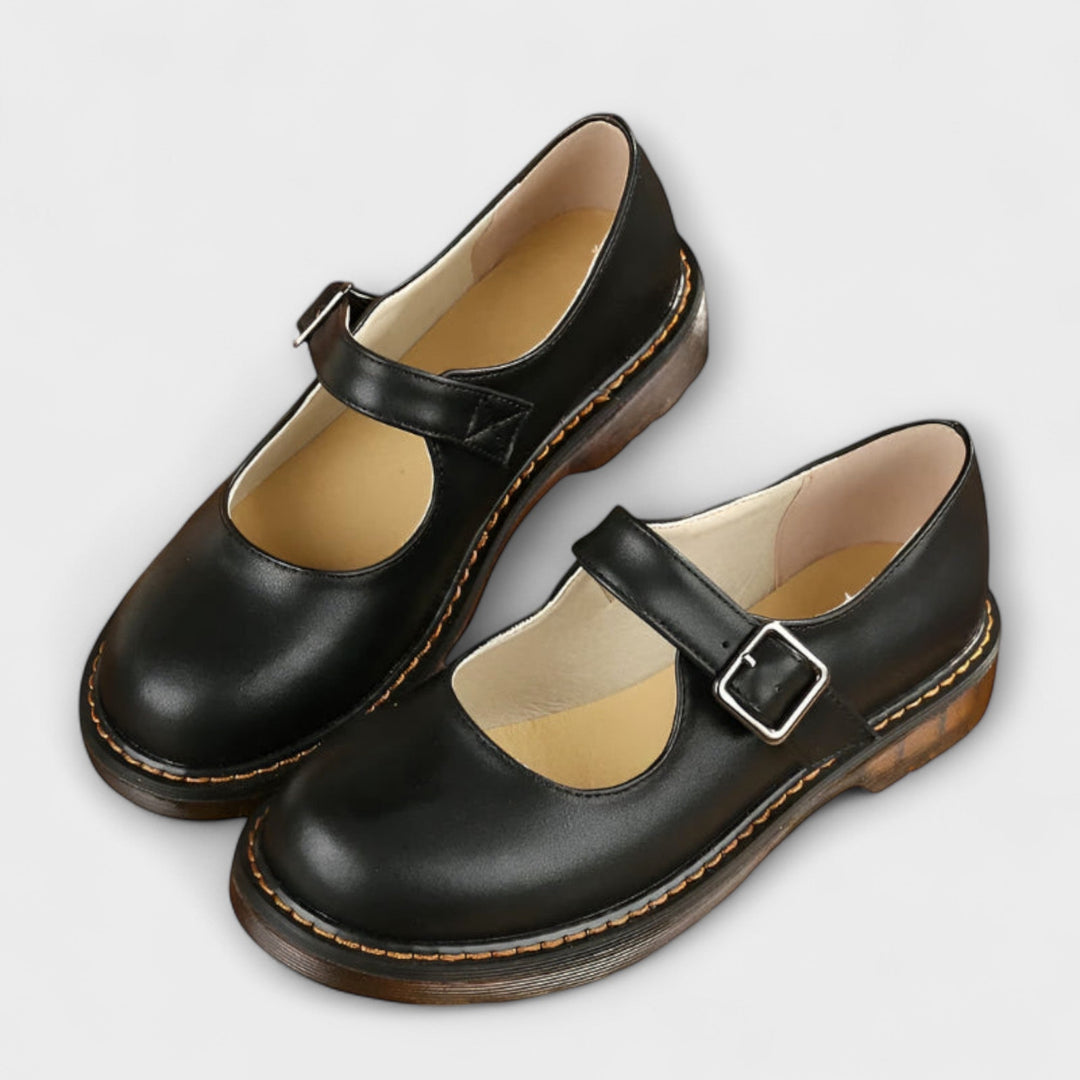 A woman wearing classic black Mary Jane flats with a dress, looking smart and comfortable.