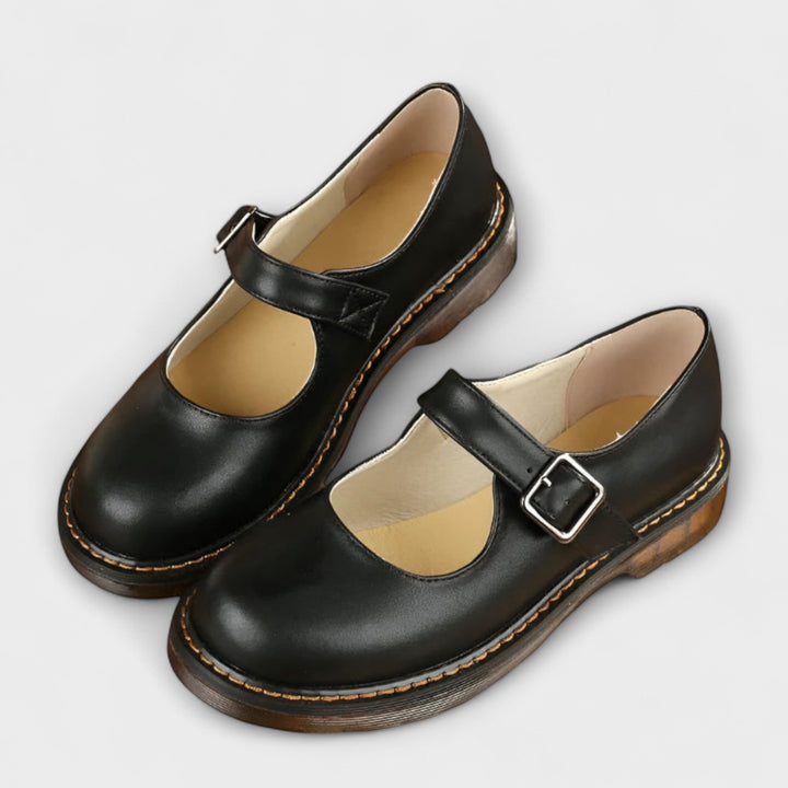 A woman wearing classic black Mary Jane flats with a dress, looking smart and comfortable.