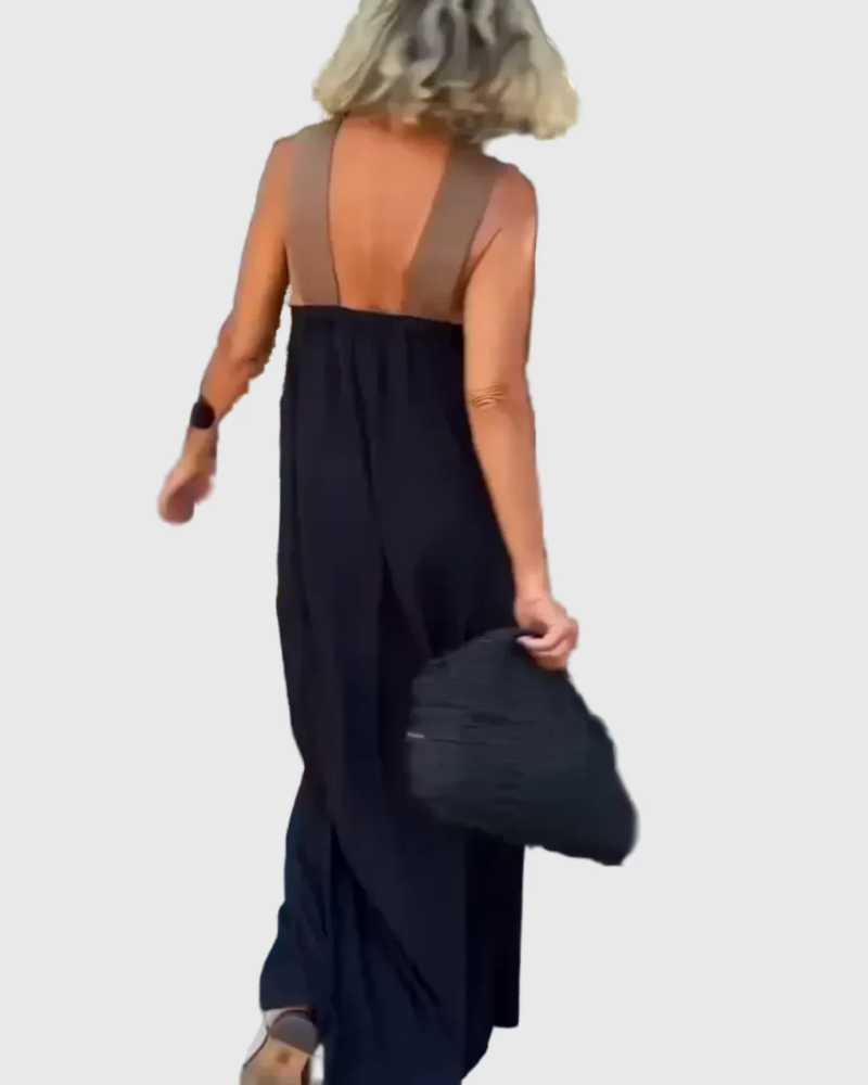 Woman wearing the Julie halterneck maxi dress in navy with a contrast crossover neckline, walking outdoors.