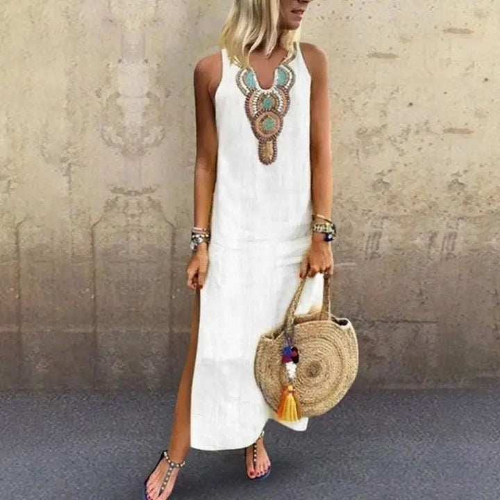 Woman in a sleeveless midi dress with embroidered neckline strolling in the summer sun.