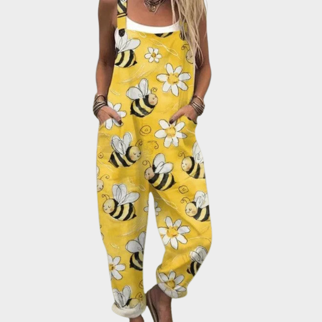 Woman wearing sunny yellow overalls printed with little bees and white daisies