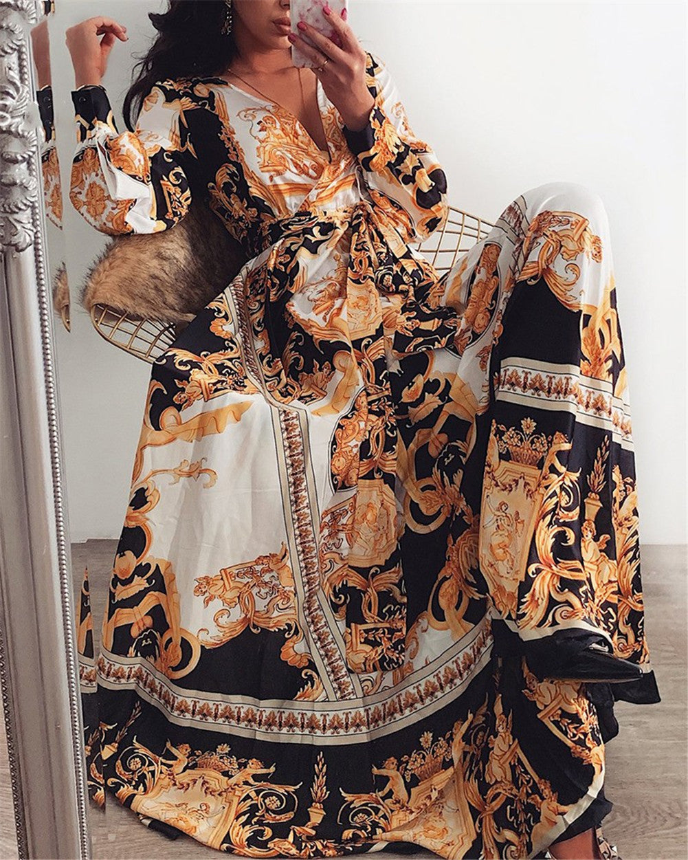 Woman at golden hour wearing the Eileen vintage print maxi dress with a waist belt and long statement sleeves.