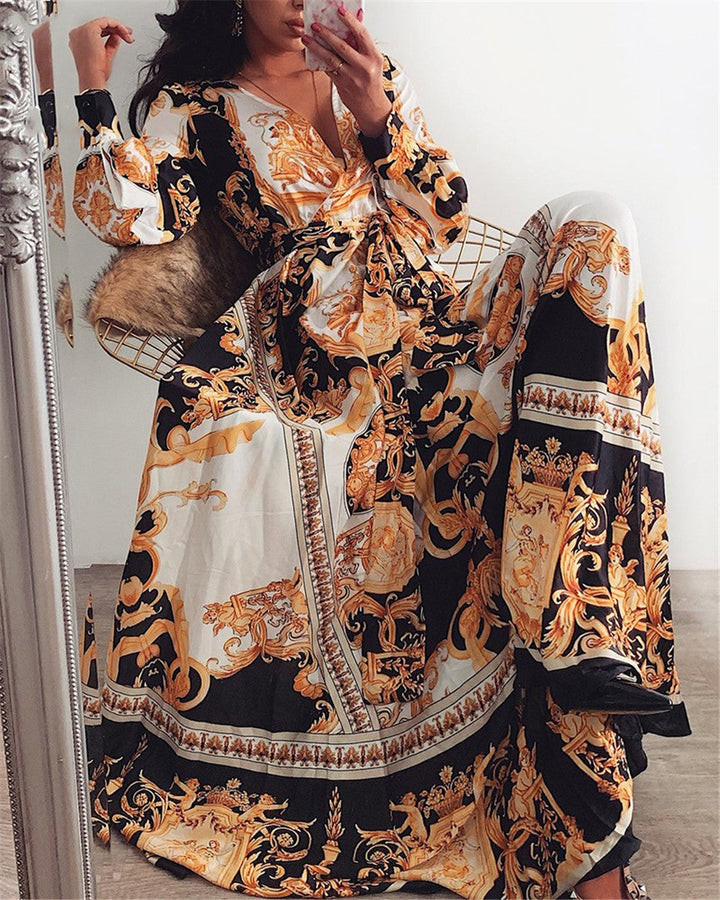 Woman at golden hour wearing the Eileen vintage print maxi dress with a waist belt and long statement sleeves.
