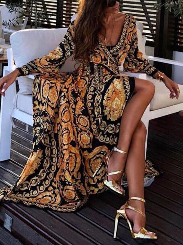 Woman at golden hour wearing the Eileen vintage print maxi dress with a waist belt and long statement sleeves.