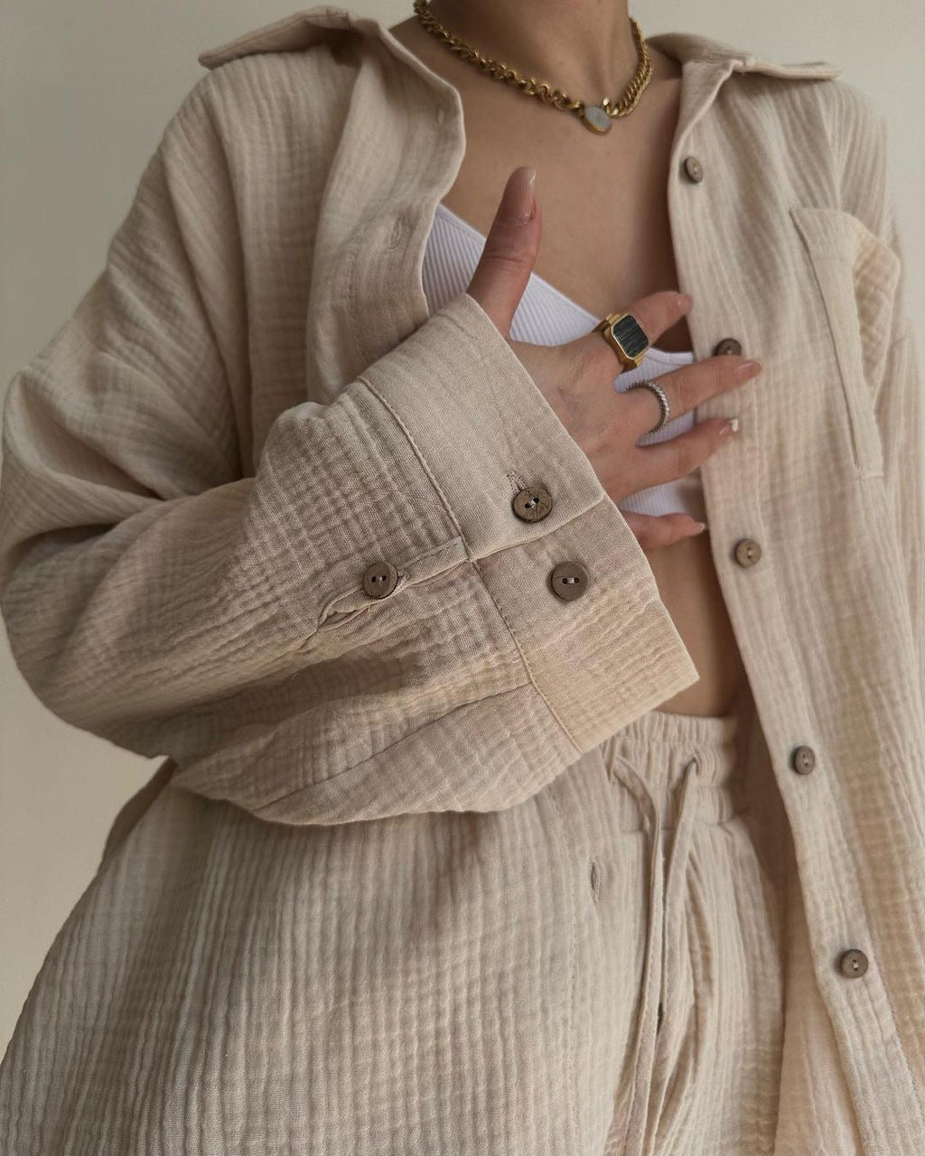 A woman wearing a flowing oversized shirt with drawstring shorts, relaxed and breezy.
