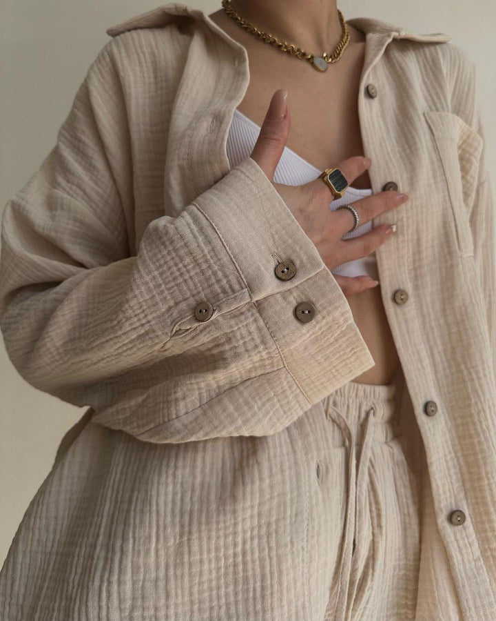 A woman wearing a flowing oversized shirt with drawstring shorts, relaxed and breezy.