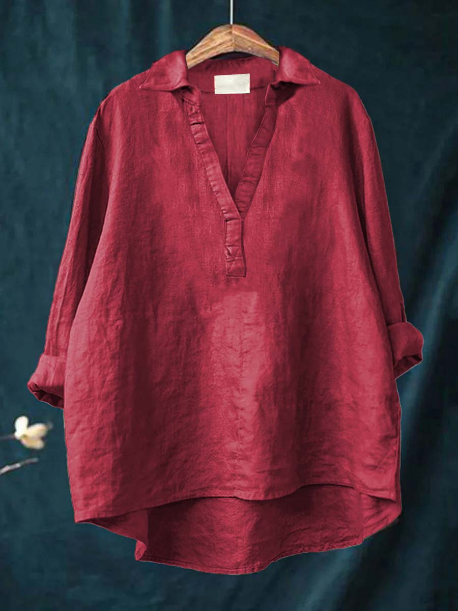 A woman wearing an elegant solid-colour summer blouse with an open V-neck, looking fresh and stylish on a warm day.