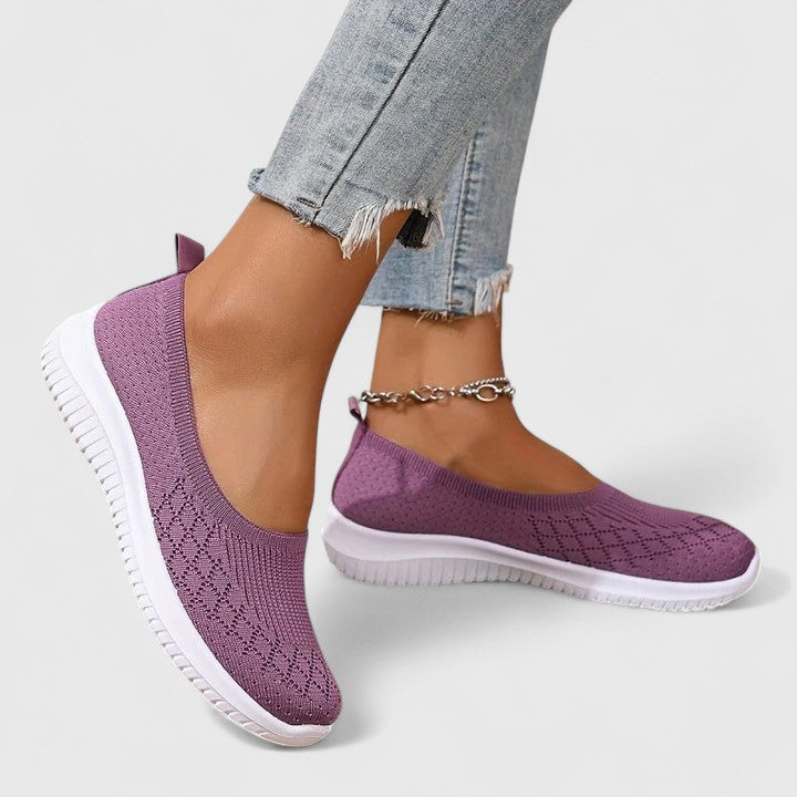 A woman slipping into soft cushioned orthopaedic slip-on shoes