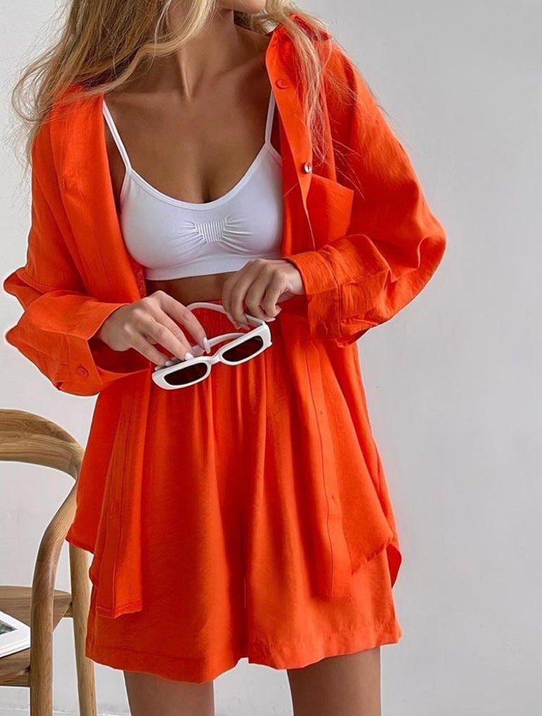 A woman wearing an oversized button-up shirt with matching high-waisted shorts.