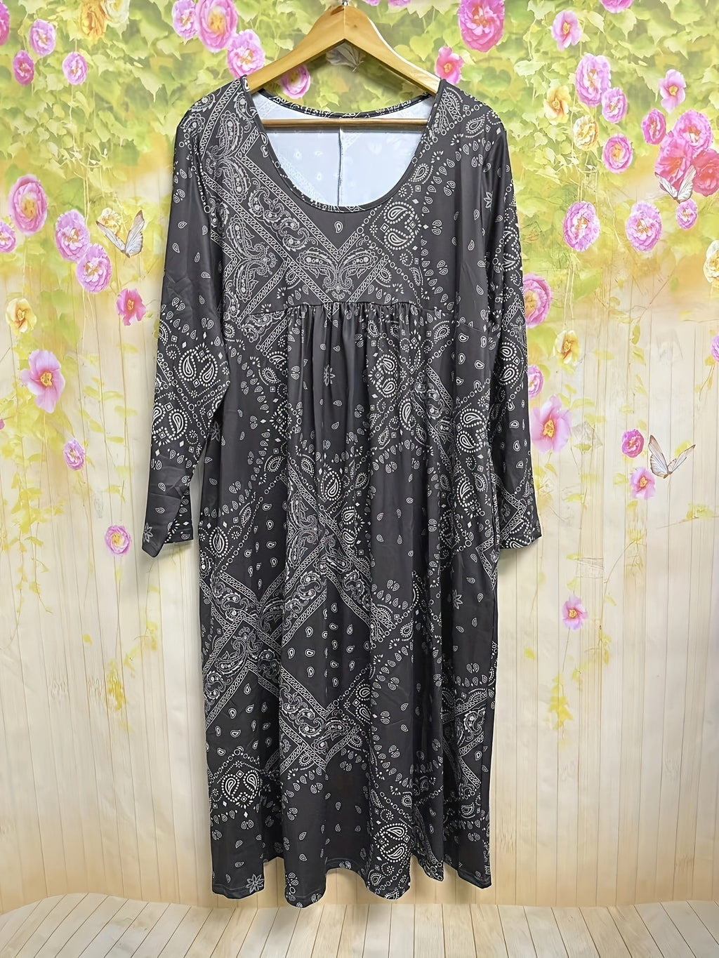 A woman wearing the Maria long sleeve grey paisley midi dress with a square neckline and flowing skirt, styled for a relaxed day out.