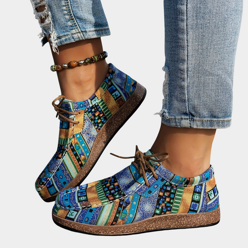 A woman wearing blue boho-print lace-up comfort sneakers while out walking.