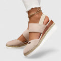 A woman in beige espadrille-inspired sandals stepping out comfortably on a bright morning.