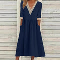 A woman wearing the Anne V-neck midi dress with delicate detailing at the collar and sleeves.