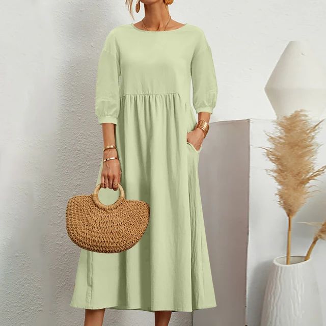 A woman wearing the Barbara fitted waist midi dress with three-quarter sleeves and a flowing skirt.