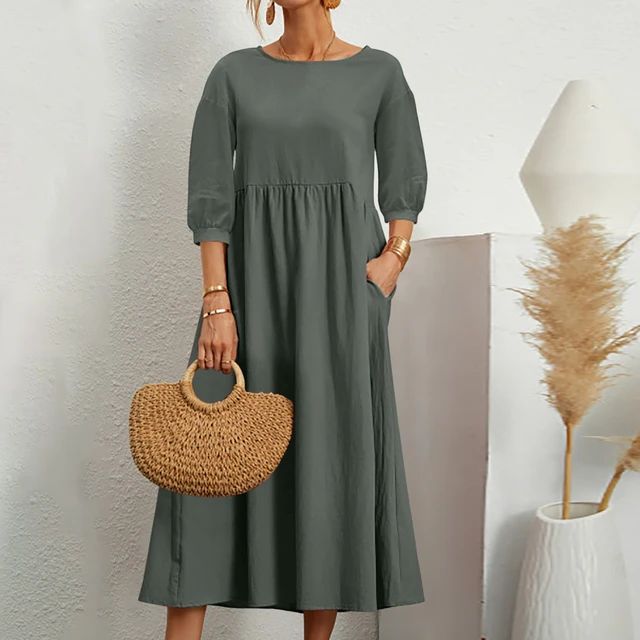 A woman wearing the Barbara fitted waist midi dress with three-quarter sleeves and a flowing skirt.