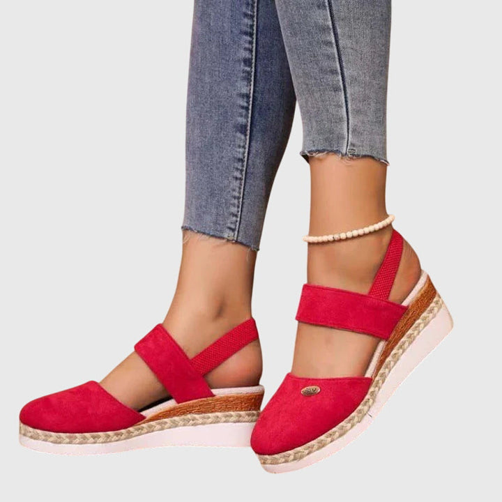 A woman wearing wide-fit supportive sandals with a summer dress, walking comfortably and looking assured.