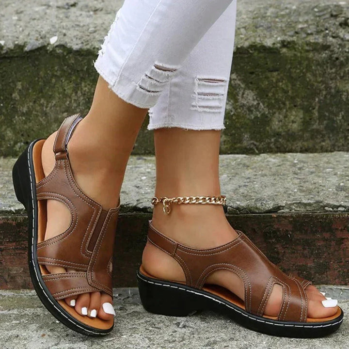 A woman wearing supportive heeled sandals with a summer dress, walking comfortably and looking relaxed.