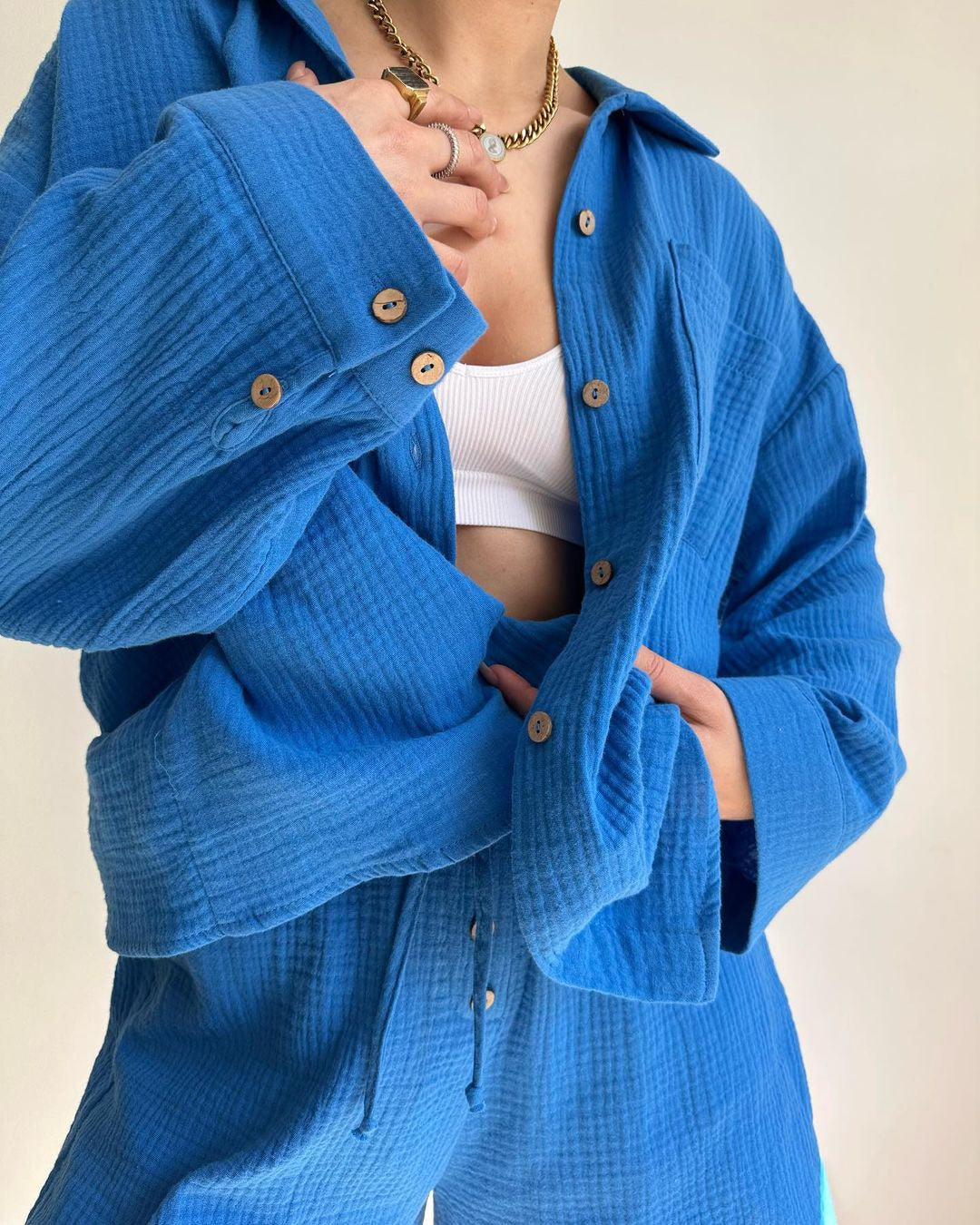 A woman wearing a flowing oversized shirt with drawstring shorts, relaxed and breezy.