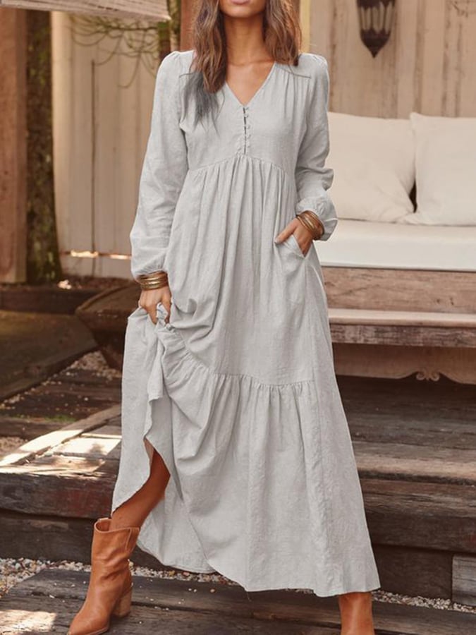 Woman walking through the countryside in the Veronique tiered maxi dress with long sleeves and a flowing flounced hem.