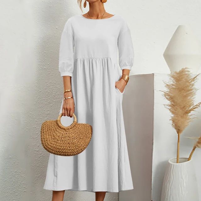 A woman wearing the Barbara fitted waist midi dress with three-quarter sleeves and a flowing skirt.