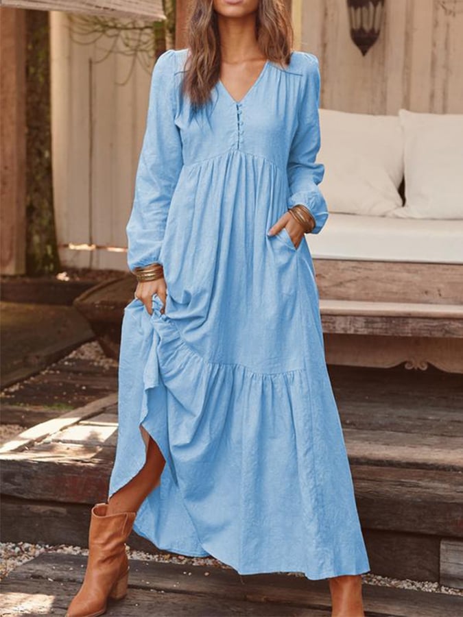 Woman walking through the countryside in the Veronique tiered maxi dress with long sleeves and a flowing flounced hem.
